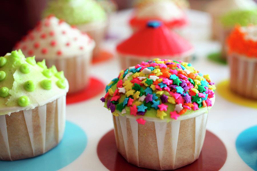 Multi-colored Cupcakes On A Tray, Focus On Cupcake With Rainbow Star Sprinkles Photograph by Doug Schneider Photography