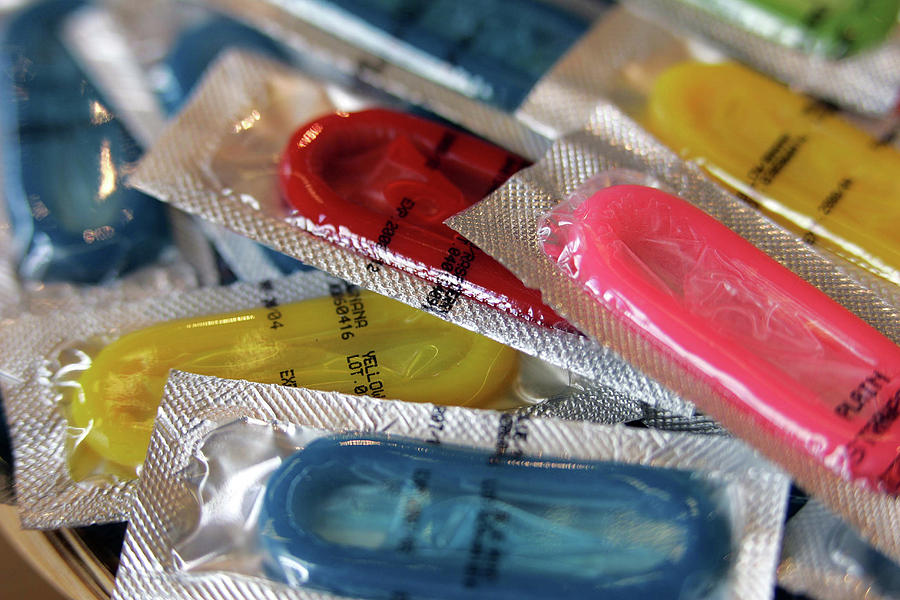 Coloured Photograph - Multi coloured condoms by Icon Photos 