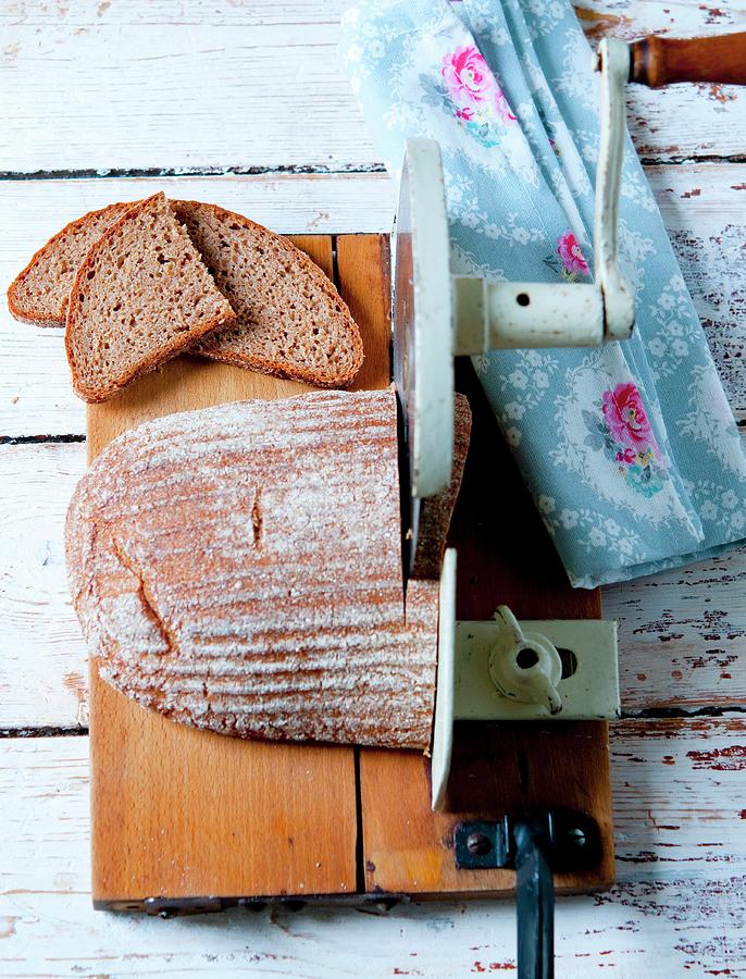 Multi-grain Bread Being Cut With A Manual Bread Machine Photograph by Udo Einenkel