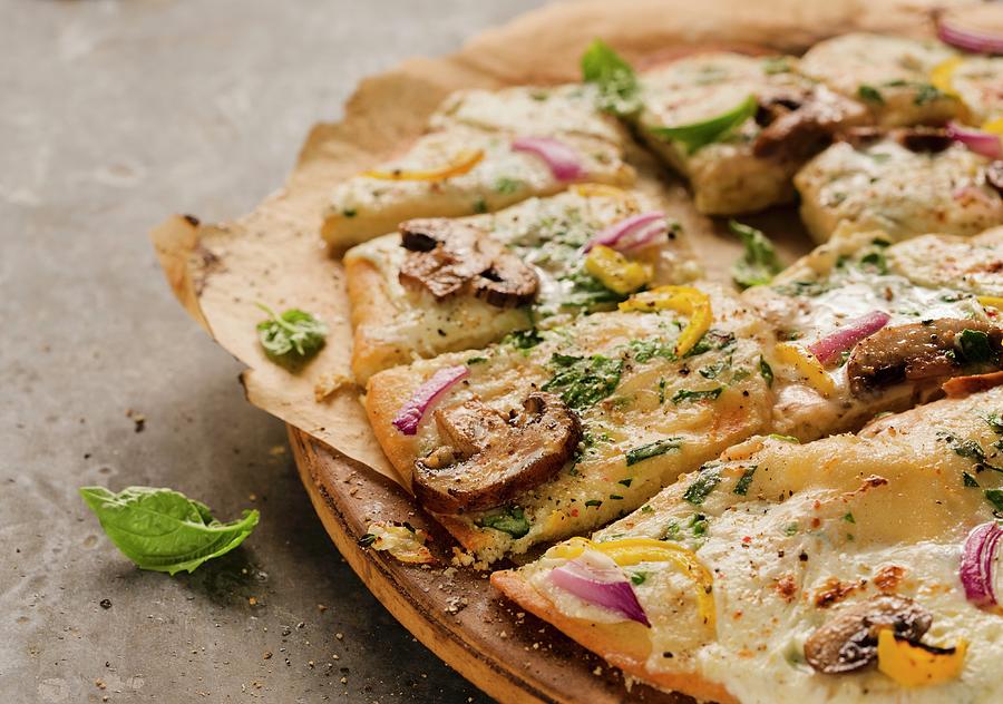Mushroom, Red Onion, Yellow Pepper And Basil Pizza; Sliced On Pizza Board Photograph by Cooke, Colin