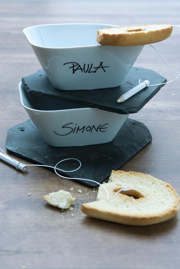 Names Written On Bowls, Small Slate Boards And Toasted Bagels Tied To Crayons With String Photograph by Matteo Manduzio