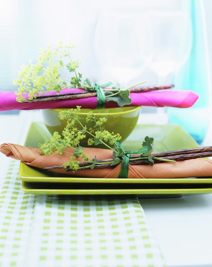 Napkin And Chopsticks Tied With Posy Of Ladys Mantle On Green Plates Photograph by Matteo Manduzio