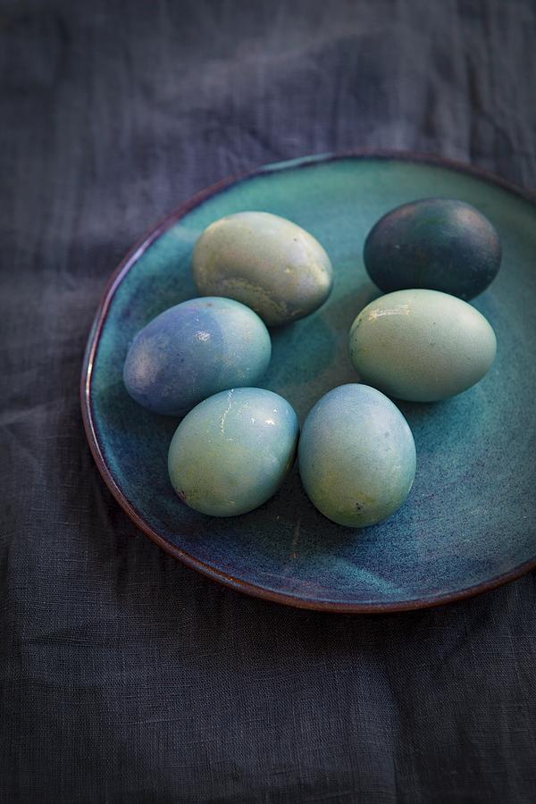 Natural Coloured Easter Eggs On A Blue Plate On A Piece Of Blue Linen Photograph by Tina Engel
