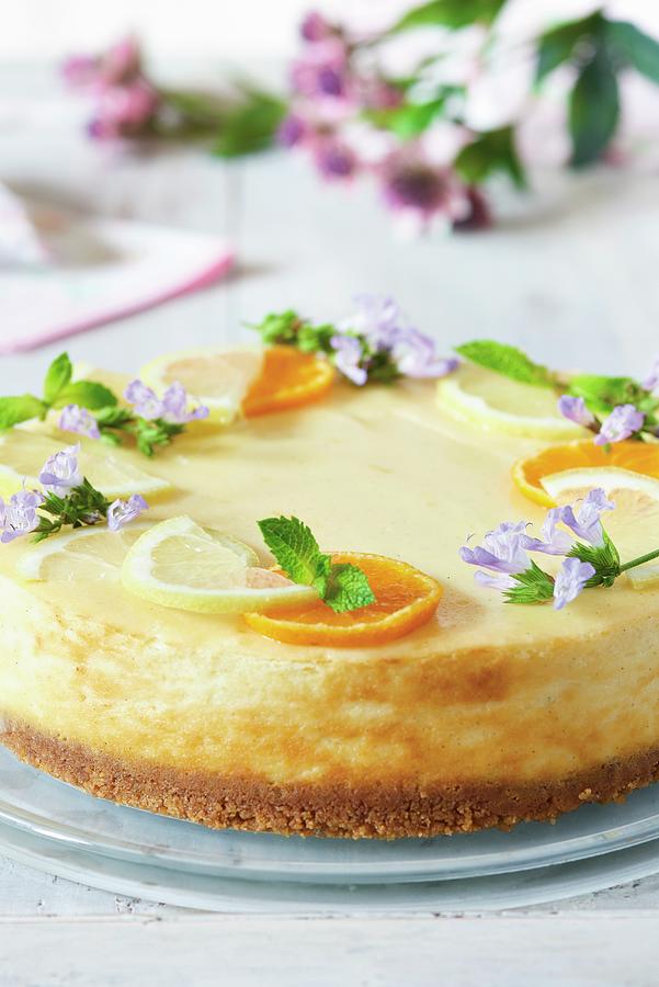 New York Cheesecake With Citrus Fruit Slices And Edible Flowers Photograph by Jonathan Short