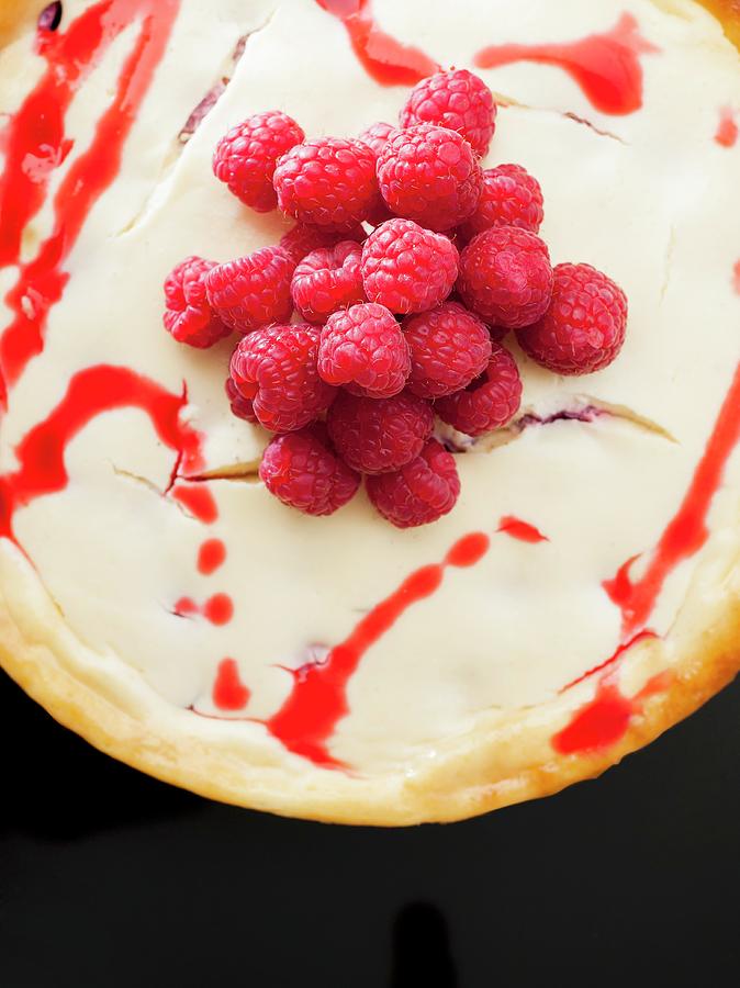 New York Cheesecake With Raspberry Sauce And Raspberries Photograph by Howarth, Craig