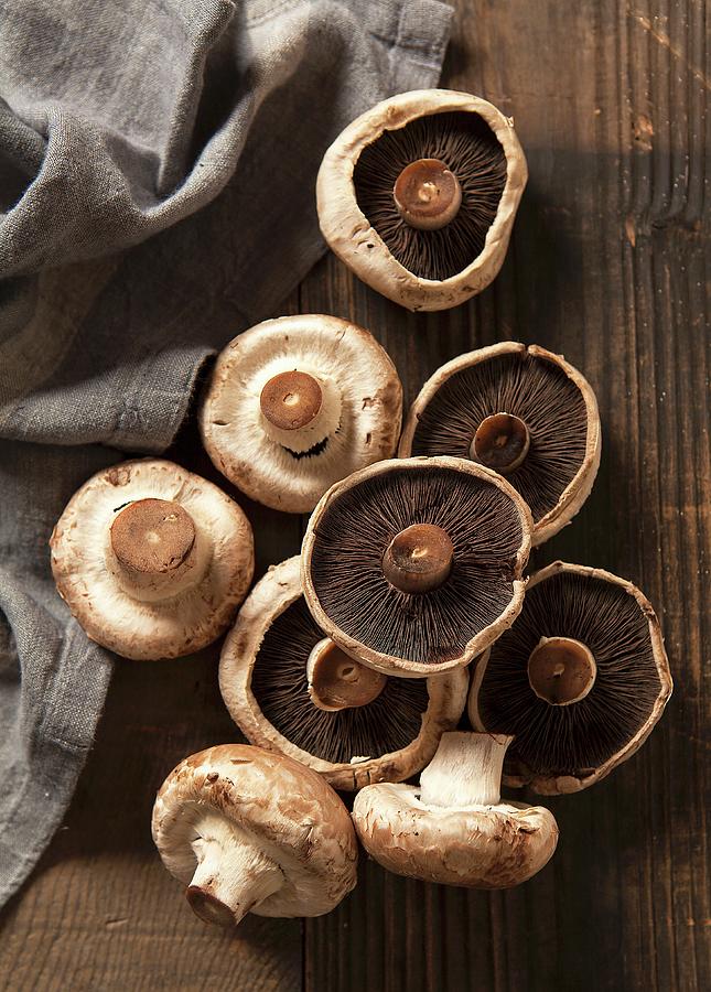 Nine Mushrooms On A Dark Chopping Board With A Grey Linen Napkin Photograph by Stacy Grant