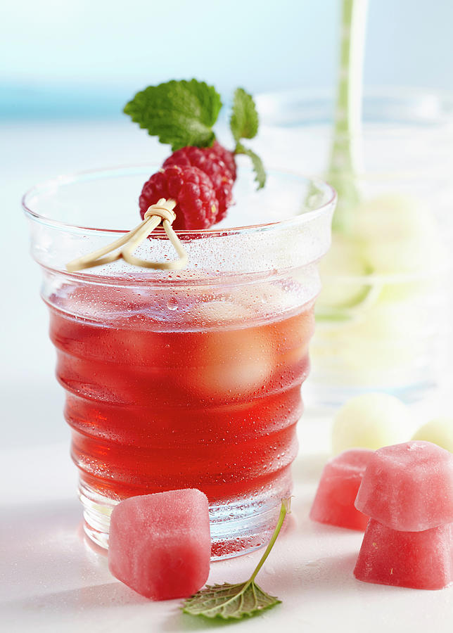 Non-alcoholic Punch With Raspberries And Honey Dew Melon Served With Pink Ice Cubes Photograph by Teubner Foodfoto