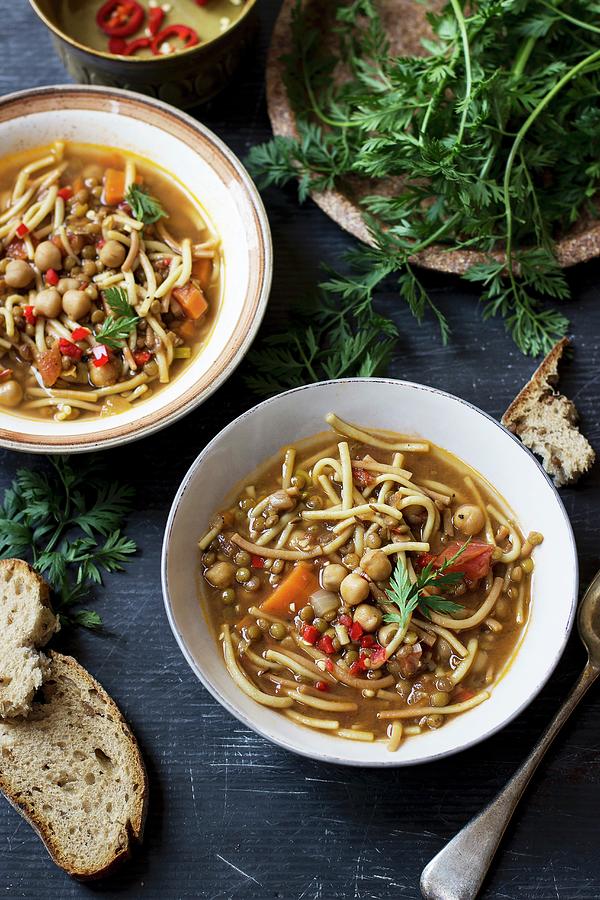 Noodle Soup With Tomatoes, Chickpea And Lentils Servced With Bread And Carrot Greens Photograph by Zuzanna Ploch