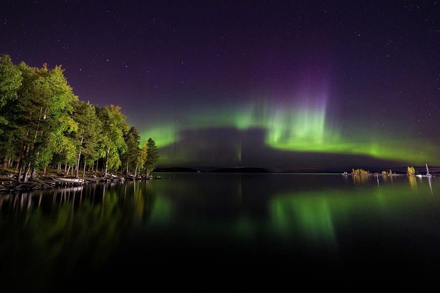 Fall Photograph - Northern lights glowing over lake by Juhani Viitanen