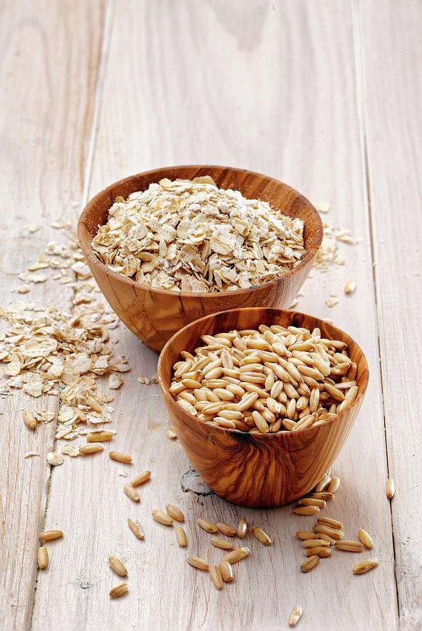 Oat Grains And Oatmeal In Wooden Bowls Photograph by Petr Gross