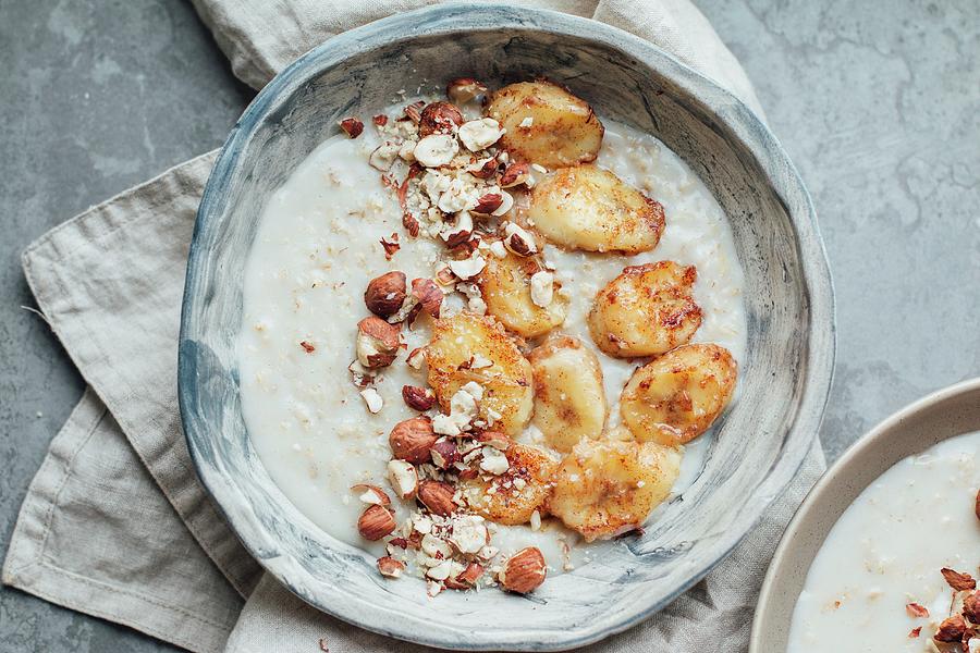 Oat Porridge With Caramelised Bananas And Hazelnuts Photograph by Kate Prihodko