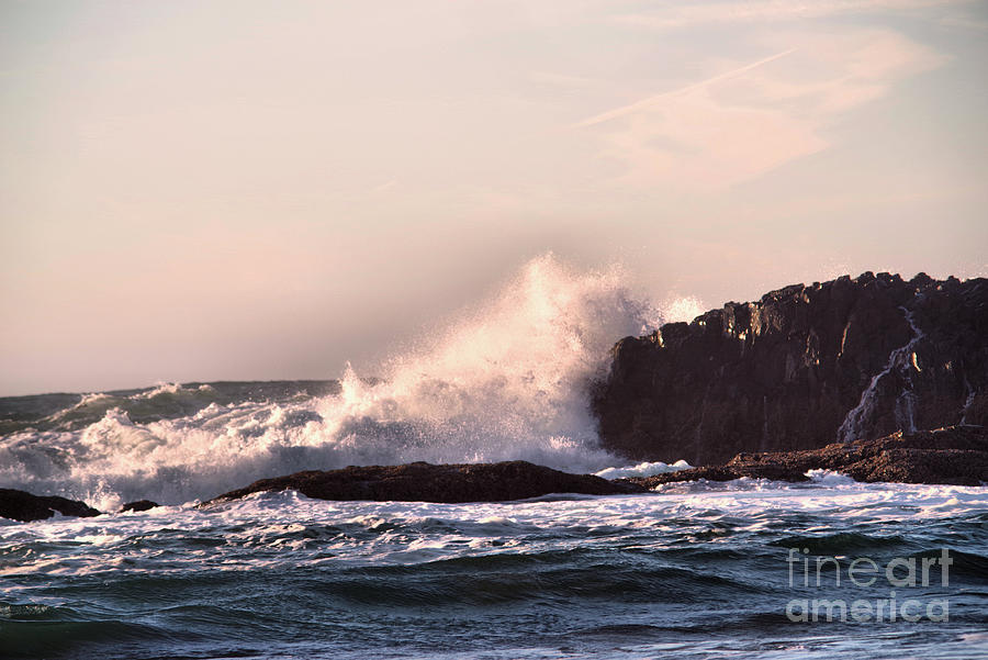 Ocean wave bursting on a rock shore Photograph by Jeff Swan