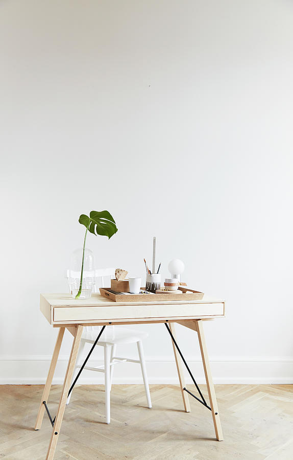 Office Supplies On Tray And Swiss Cheese Plant Leaf In Vase On Pale Wooden Desk Photograph by Nicoline Olsen