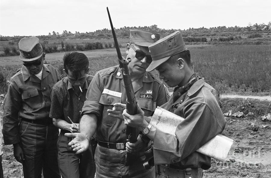 Rifle Photograph - Officers Examining Weapon In Vietnam by Bettmann