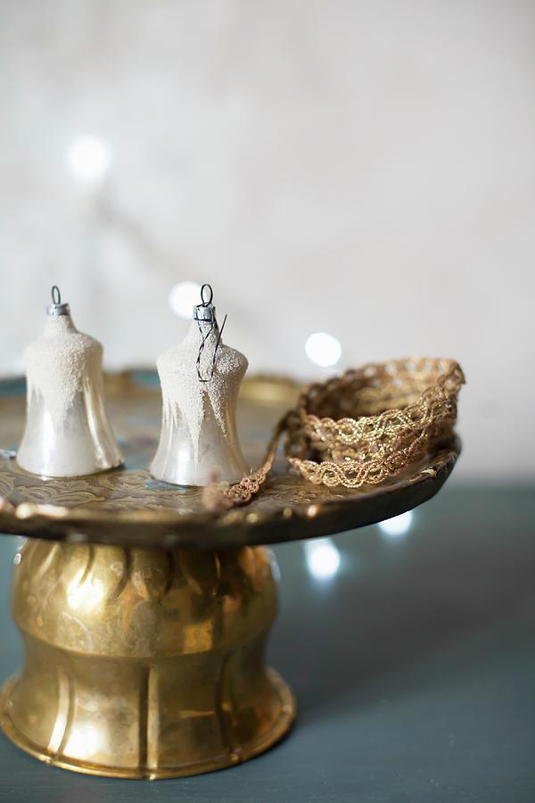 Old Christmas-tree Decorations And Brocade Ribbon On Cake Stand Photograph by Alicja Koll