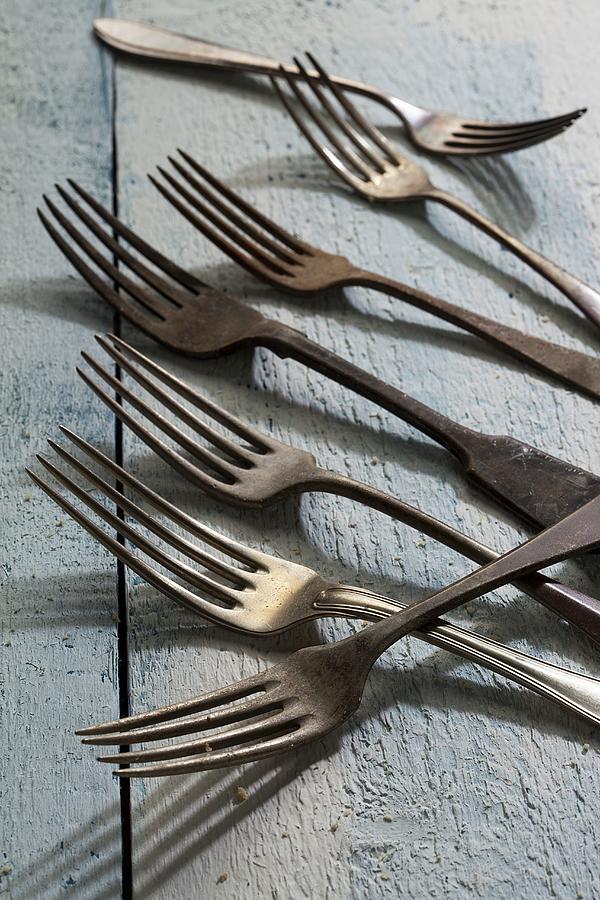 Old Forks On A Wooden Surface Photograph by Blueberrystudio