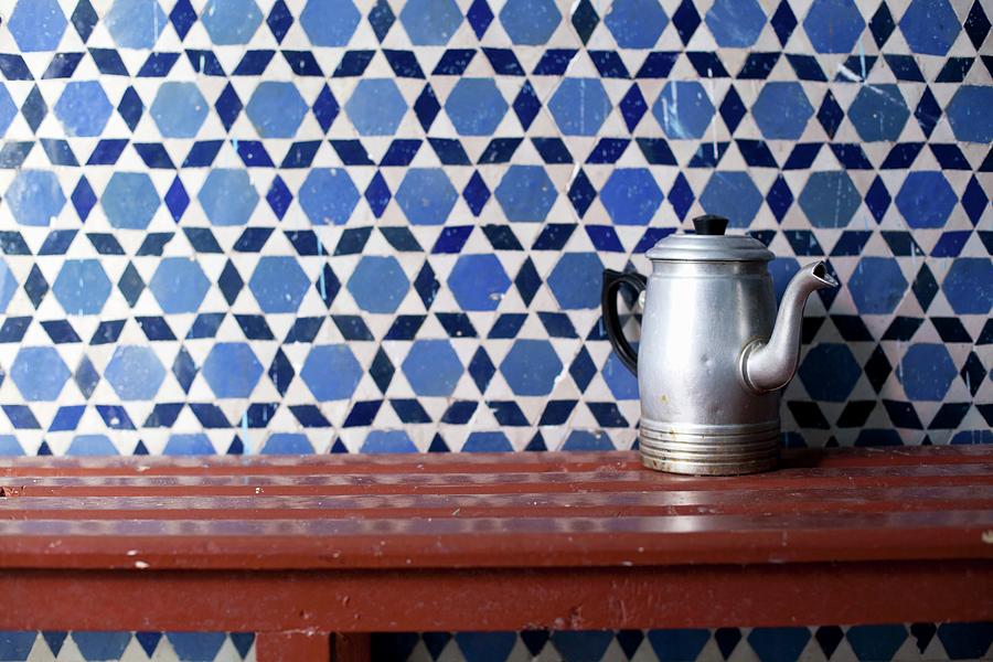 Old Metal Coffee Pot On Wooden Table Against Tiled Wall Photograph by Klaus Arras