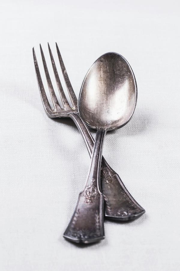 Old Silver Cutlery On A White Table Cloth Photograph by Natasha Breen