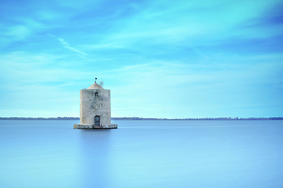 Old spanish windmill in a blue lagoon. Orbetello, Argentario, Italy. Photograph by Stefano Orazzini
