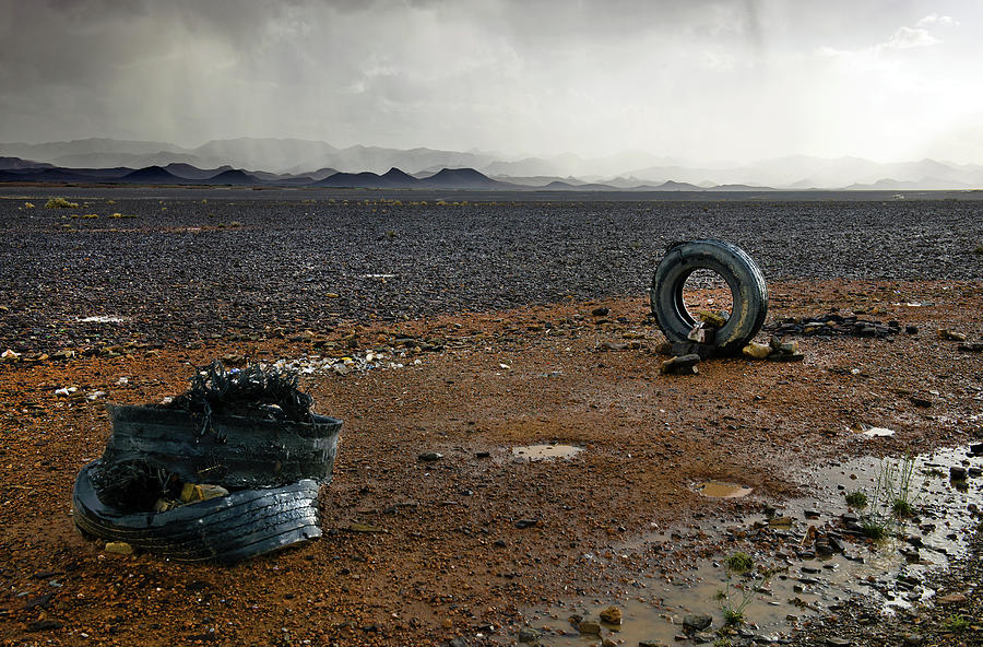 Old Tyres In Moroccan Desert Storm Photograph by Pavliha