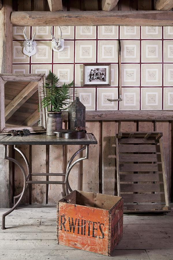 Old Wooden Crate In Front Of Metal-framed Side Table And Checked Wallpaper In Rustic Attic Interior Photograph by Annette Nordstrom