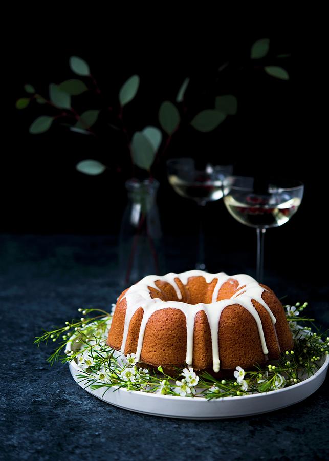 Olive Oil And Orange Ring Cake On A Plate With Champagne Glasses In The Background Photograph by Lisa Rees