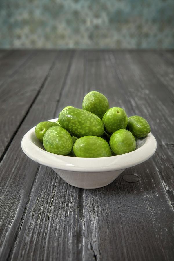 Olives from Arbosana, Chile In A Bowl On A Wooden Surface Photograph by Giorgio Scarlini