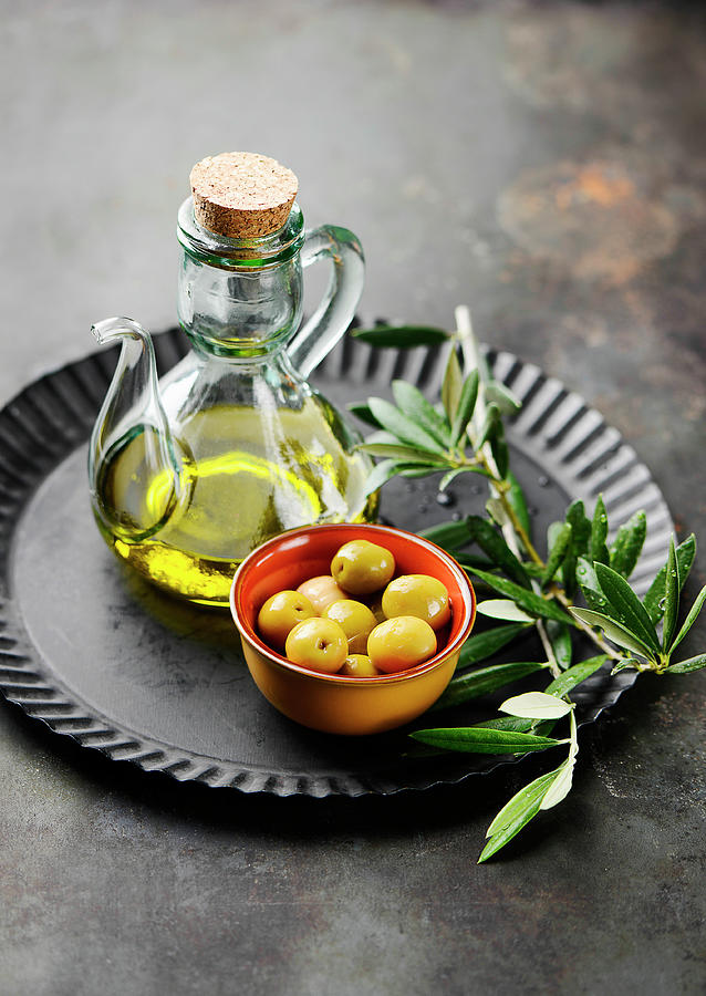 Olives, Olive Oil And An Olive Sprig Photograph by Ewgenija Schall
