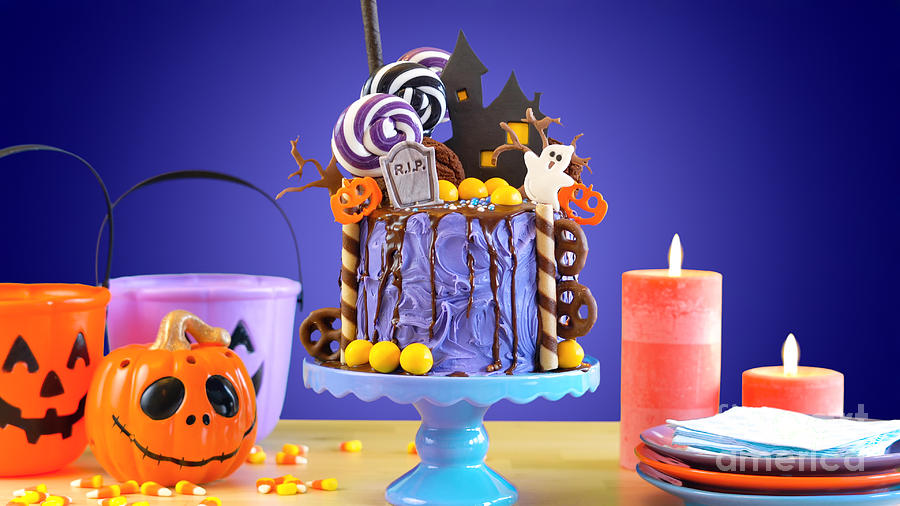 Halloween Photograph - On trend Halloween candyland novelty drip cake in colorful purple party setting. by Milleflore Images
