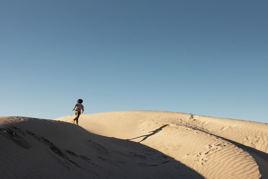 Nature Photograph - One Kid Runs On The Ridge Of A Dune At Dunas De La Soledad by Cavan Images