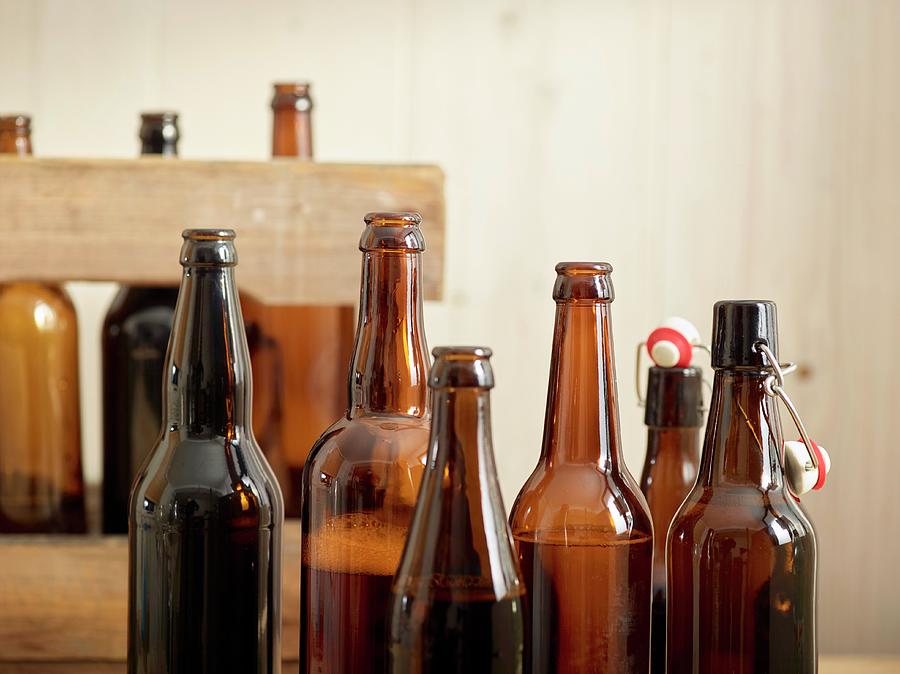 Open Beer Bottles In Front Of A Wooden Crate Photograph by Christopher Mick
