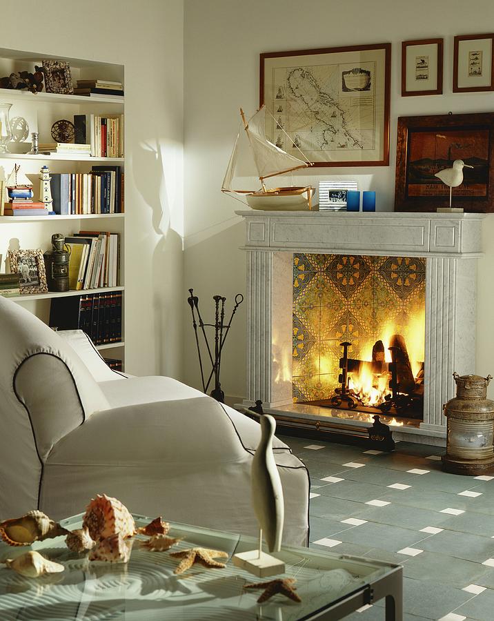Open Fireplace With Tiled Fireback In Living Room With White Leather Couch And Maritime Decor Photograph by Laura Rizzi