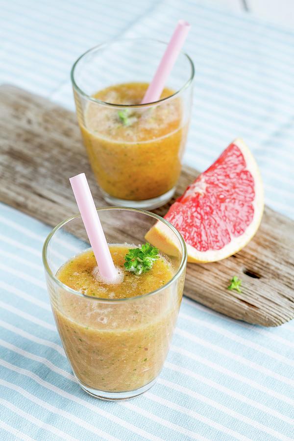 Orange And Grapefruit Smoothie With Parsley Photograph by Claudia Timmann
