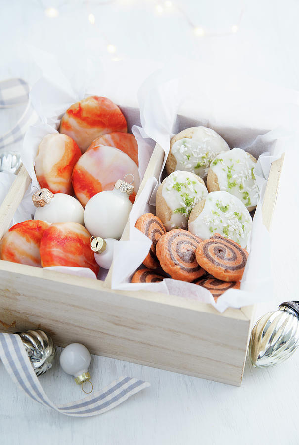 Orange Biscuits With Marbled Orange Icing, Orange And Chocolate Pinwheel Biscuits And Lime And Coconut Shortbread Biscuits All In A Wooden Gift Box With Tissue Paper Photograph by Victoria Firmston
