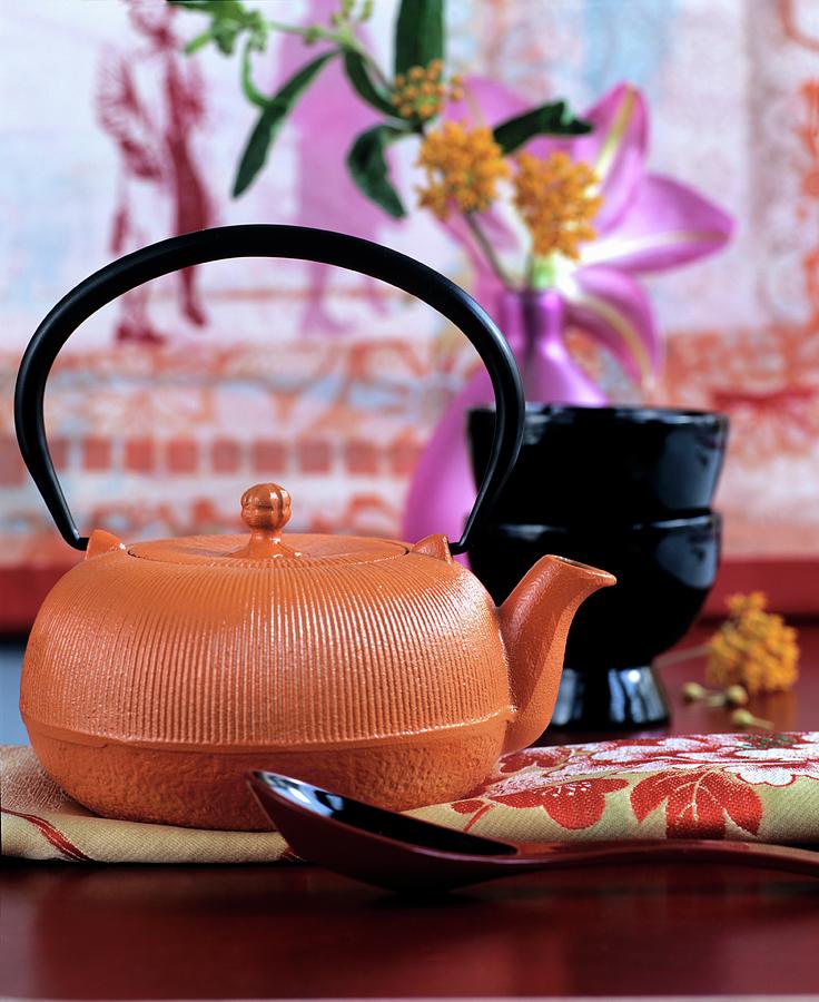 Orange Cast Iron Teapot Arranged With Red And Pink Decorations Photograph by Matteo Manduzio