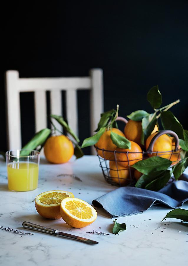 Orange Juice And Fresh Oranges On The Table Photograph by Laura Negrato