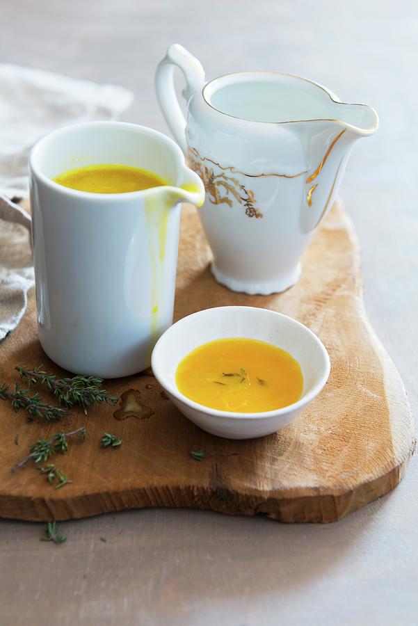 Orange Sauce In A Jug On A Wooden Board Photograph by Veronika Studer