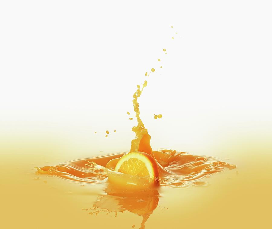 Orange Slice Falling Into Orange Juice Photograph by Krger & Gross
