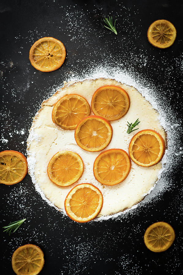 Orange Tart With Orange Slices, Yoghurt Cream, Rosemary And Icing Sugar Photograph by M. Nlke