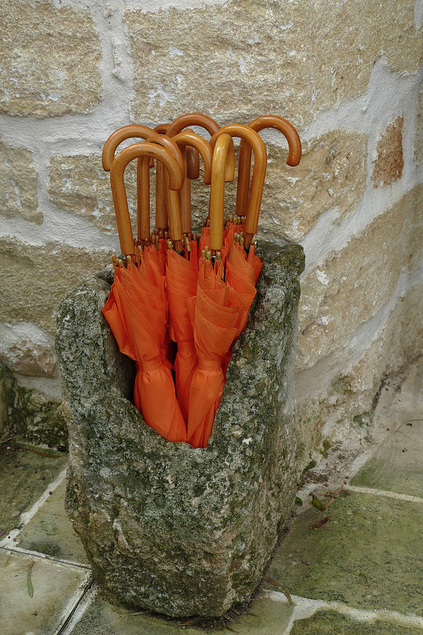 Orange umbrellas in an ancient stone stand Photograph by Steve Estvanik