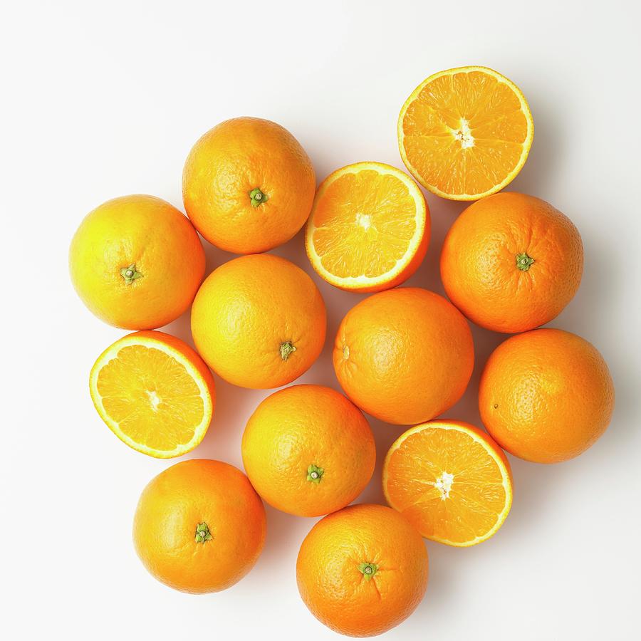Oranges, Whole And Halved On A White Surface seen From Above Photograph by Studio R. Schmitz