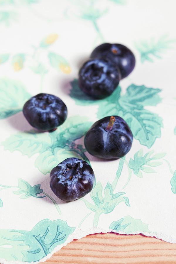 Organic Blueberries On A Piece Of Floral-patterned Wallpaper Photograph by Miriam Rapado