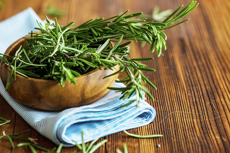 Organic Fresh Rosemary Herb On Textile Napkin On Wooden Table Photograph by Anna Bogush
