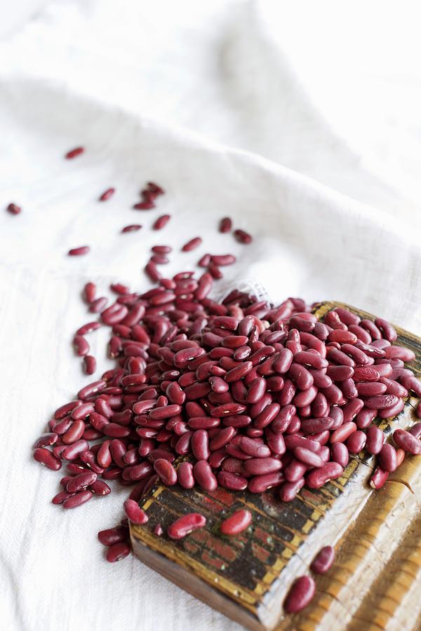 Organic Kidney Beans On A Linen Cloth And On A Wooden Board Photograph by Sabine Lscher