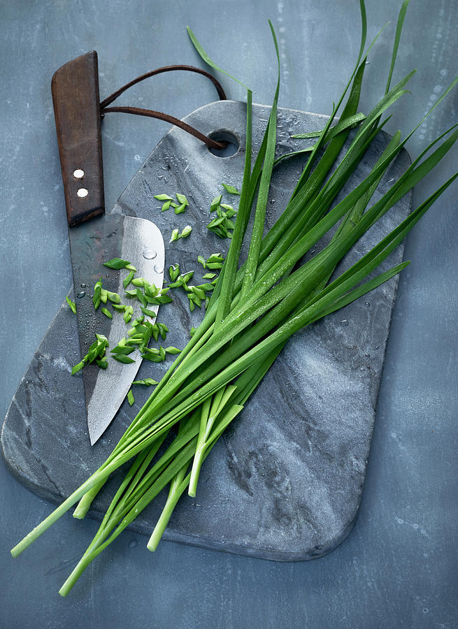 Oriental Garlic-chives On A Grey Marble Board With A Knife Photograph by Stefan Schulte-ladbeck