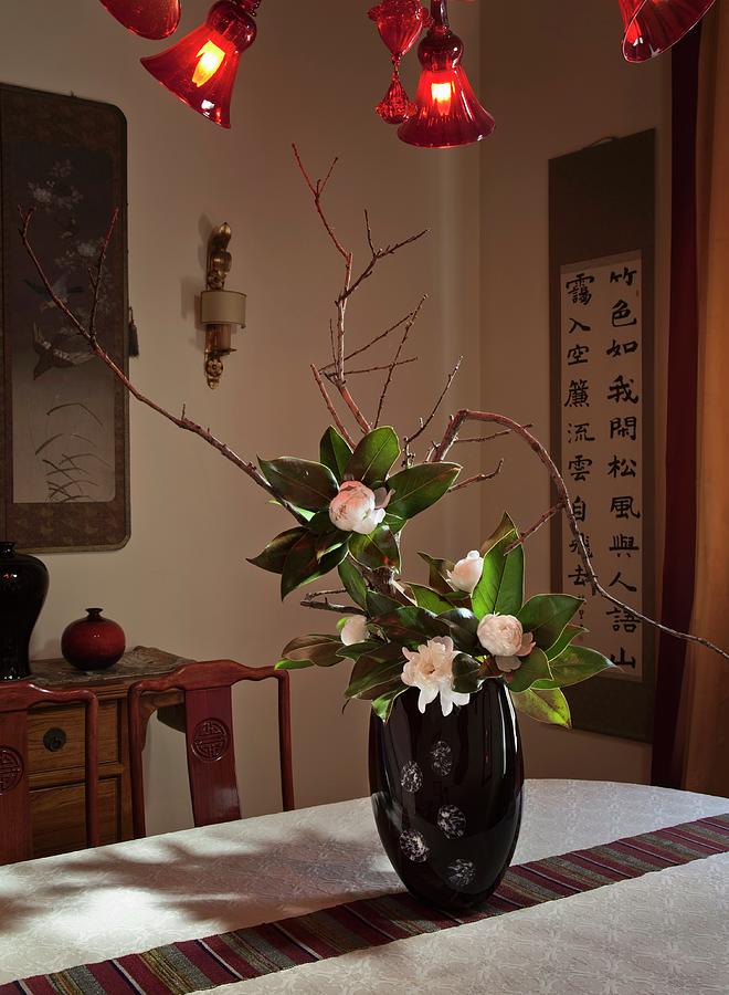 Oriental-style Living Area With Chinese Wall Hangings And Flower Arrangement In Black Lacquer Vase Photograph by Laura Rizzi