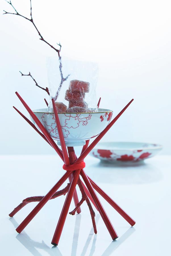 Oriental Table Decoration: Oriental Bowl Balanced On Red Chopsticks Photograph by Matteo Manduzio
