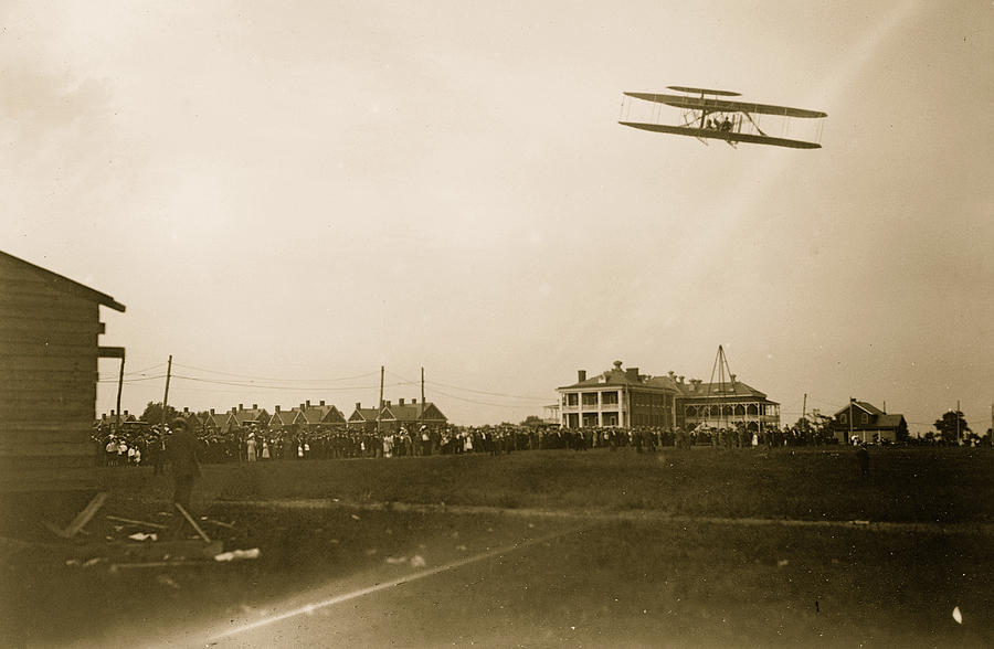 Orville Wright flying in his airplane, crowd on field Painting by 