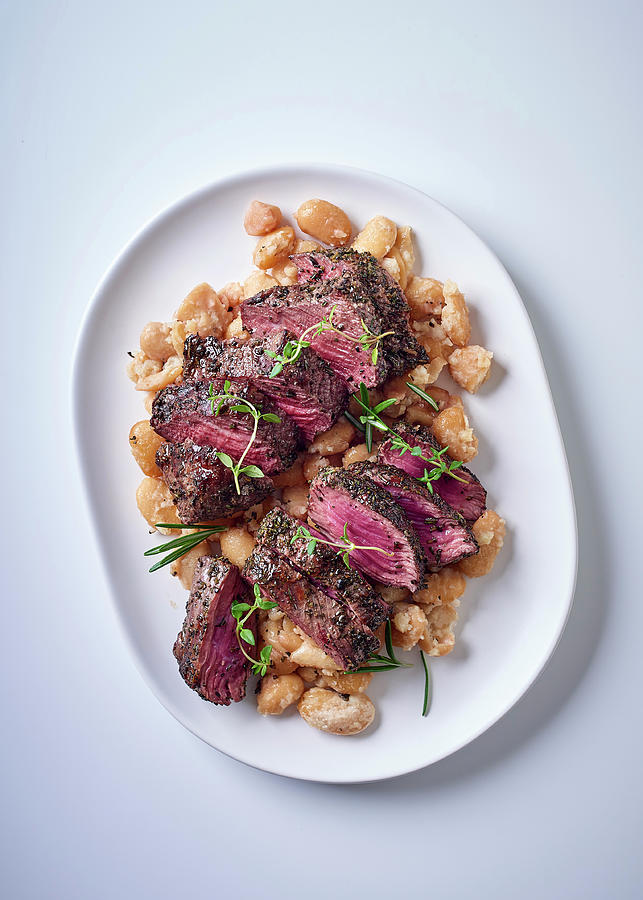 Ostrich Steaks On Lima Beans With Garlic And Rosemary Photograph by Great Stock!
