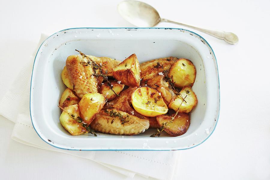 Oven-roasted Potatoes And Chicken Wings With Lemons And Thyme Photograph by Charlotte Tolhurst